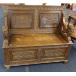 A carved oak monks bench.