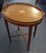 A mahogany oval side table with scalloped edging.