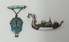 Three enamelled brooches including sterling silver peacock and silver Siam dragon ship