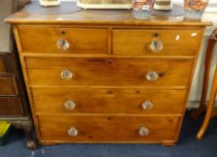 A Victorian stained pine chest fitted with five drawers and glass knob handles.