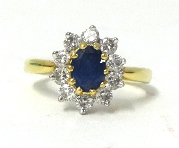 An 18ct sapphire and diamond cluster ring, circa 1990, size R.