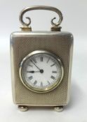 A silver cased travel clock, with French movement and platform escapement, on bun feet, height 9.