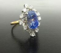 A fine sapphire and diamond cluster ring set with a .large fancy cut blue sapphire surrounded by