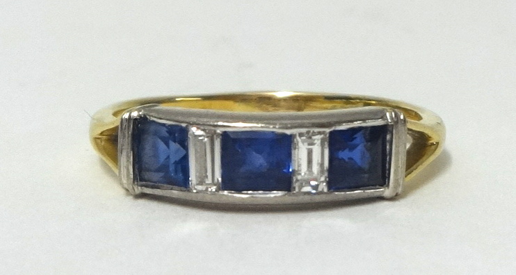 A sapphire and diamond ring, set with 3 square cut blue sapphires and 2 baguette cut diamonds,