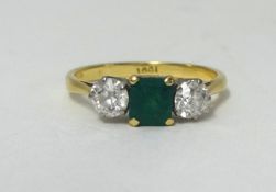 An 18ct diamond and emerald set three stone ring.