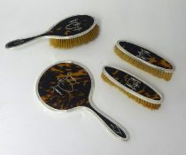 A silver backed, inlaid and tortoishell four piece brush set.