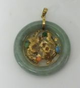 A Jadeite pendant set with gold dragon mounted with coloured stones, 35mm,