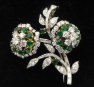 A beautiful diamond and emerald set floral design brooch. Set as two cluster formations with