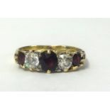 An antique 18ct gold five stone ring set with garnets and diamonds, size Q.