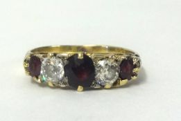 An antique 18ct gold five stone ring set with garnets and diamonds, size Q.
