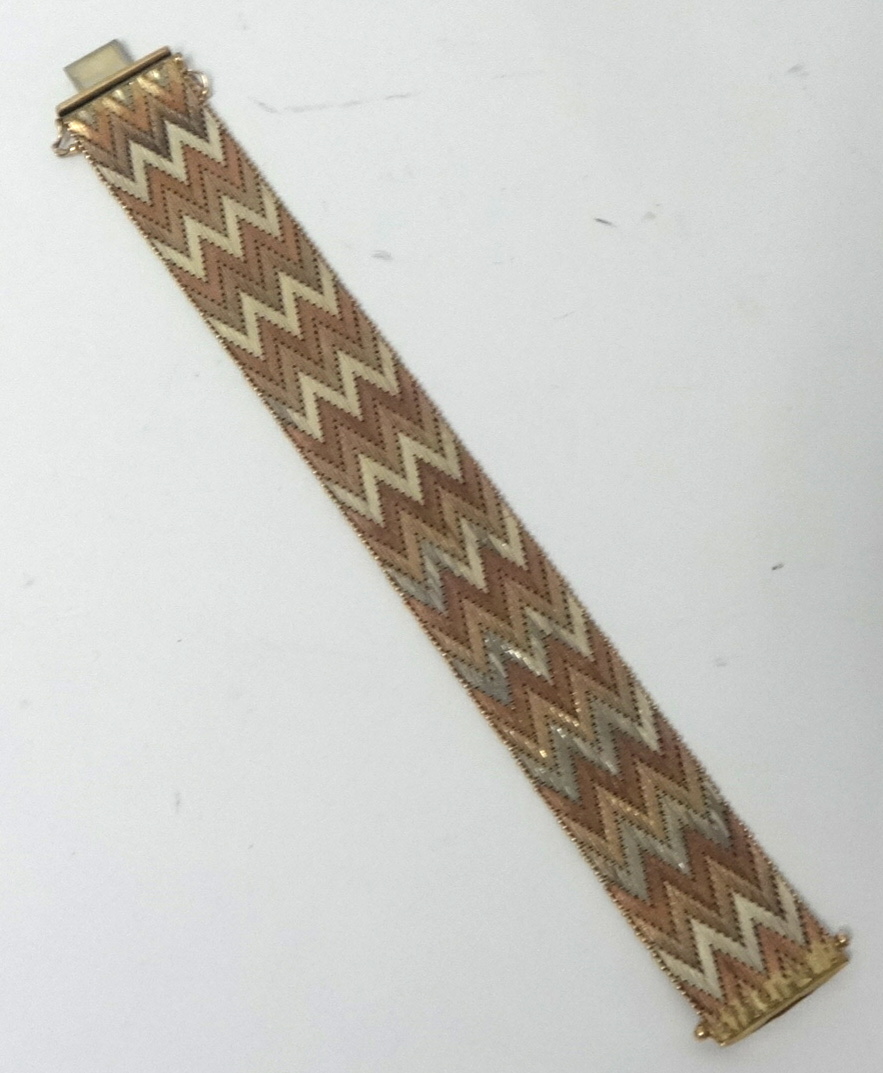 A 9K bracelet, yellow, white and rose gold in a chevron design, approx 66.10g, 19cm x 2cm.