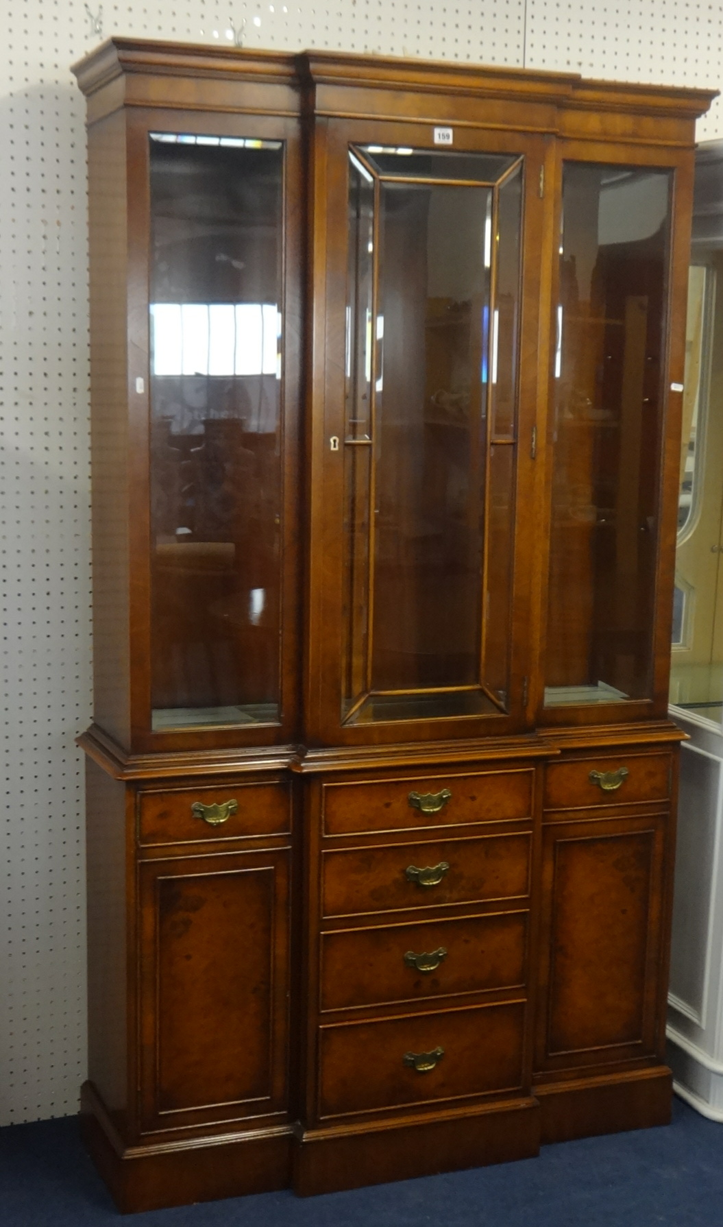 A modern walnut display cabinet, with glazed upper section, breakfront outline.