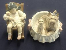 Two Lladro figures (child in rocking chair and basket with dogs).