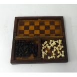 A carved ebony and ivory small antique travelling chess set possibly prisoner of war.