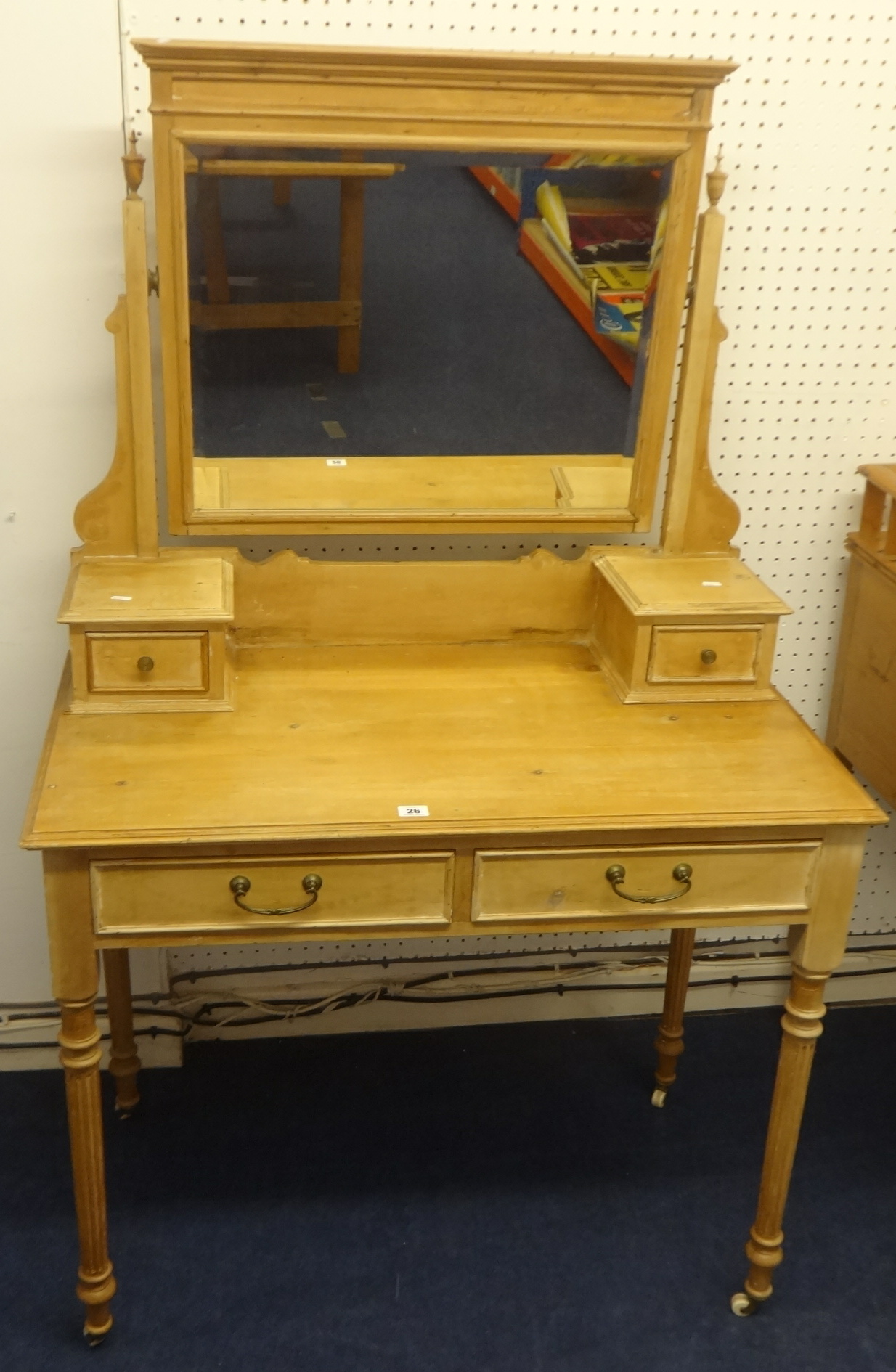 A pine dressing table with fluted legs and white china casters.