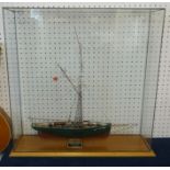 A scale model ship 'The Ranger' in glazed cabinet.