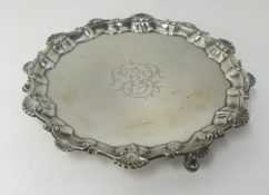 A Victorian silver salver, with patterned and shell border, on three hoof feet, approx 9oz.