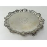 A Victorian silver salver, with patterned and shell border, on three hoof feet, approx 9oz.