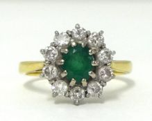 An 18ct emerald and diamond cluster ring, finger size R.