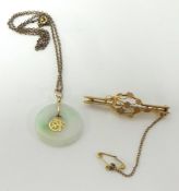 A Jade pendant and chain and a 9ct gold antique brooch.