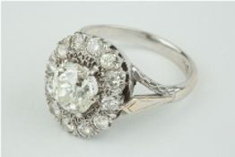 A fine diamond cluster ring, the centre old cut diamond approx 3.00 carats, set within a cluster