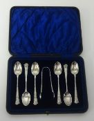 A Geo V seven piece silver set of pretty teaspoons and pair tongs in fitted case.