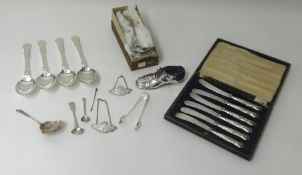 A collection of silver plated flatware, two silver spirit labels, sugar tongs, two silver spoons,