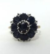 An 18ct nine stone sapphire and white sapphire set cluster ring, finger size O.