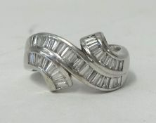 A white gold band, shaped as a ribbon, 18k, set with baguette cut diamond, approx .79 ct, size M.