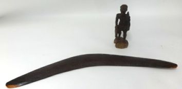 A carved wood boomerang and a carved wood figure