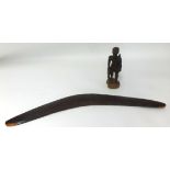 A carved wood boomerang and a carved wood figure
