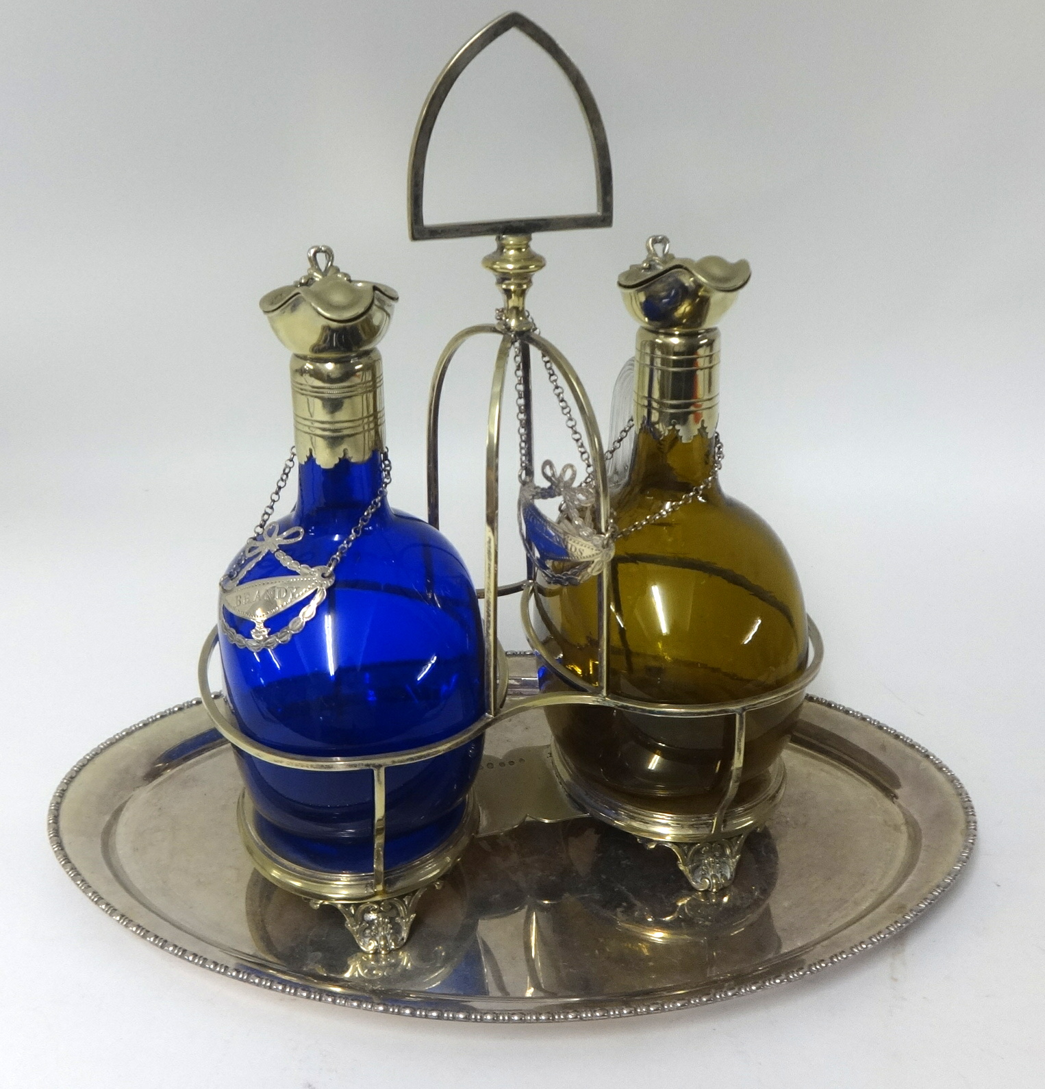 A double decanter set, comprising a pair of coloured glass Rum and Brandy decanters set within a