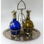 A double decanter set, comprising a pair of coloured glass Rum and Brandy decanters set within a