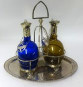 A double decanter set, comprising a pair of coloured glass Rum and Brandy decanters set within a