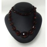 A cherry amber/Bakelite string of faceted beads.