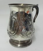 A mid Victorian silver baluster shaped tankard, with embossed decoration of grape vines, with a
