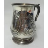 A mid Victorian silver baluster shaped tankard, with embossed decoration of grape vines, with a