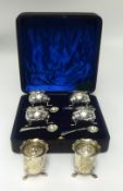 A set of four silver table salts each with blue glass liner, on paw feet with original mustard