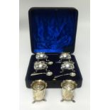 A set of four silver table salts each with blue glass liner, on paw feet with original mustard