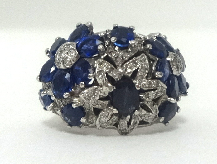 A fancy diamond and sapphire flower ring, finger size N.