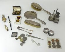 A three piece silver back dressing table set, pair silver napkin rings, general coins, cufflinks,