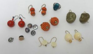 A collection of various earrings including cameo earrings, coral and others.