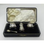 Three piece silver condiment set, cased.