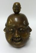 A large bronze four face Buddha head and a similar miniature model (2).