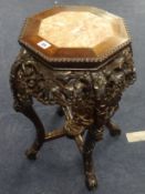 A Chinese carved hardwood stand with marble insert.