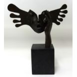 A contemporary bronze sculpture on black marble plinth.