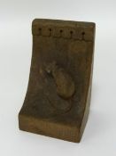 In the style of Robert 'Mouseman' Thompson, a single carved wood bookend with mouse carving.