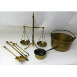 A large brass jam pan, a brass skillet, set of brass scales, weights and fire irons.