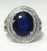 A 14ct white gold and diamond ring set with an oval cut blue sapphire, approx 6.75cts, diamonds 1.