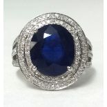 A 14ct white gold and diamond ring set with an oval cut blue sapphire, approx 6.75cts, diamonds 1.